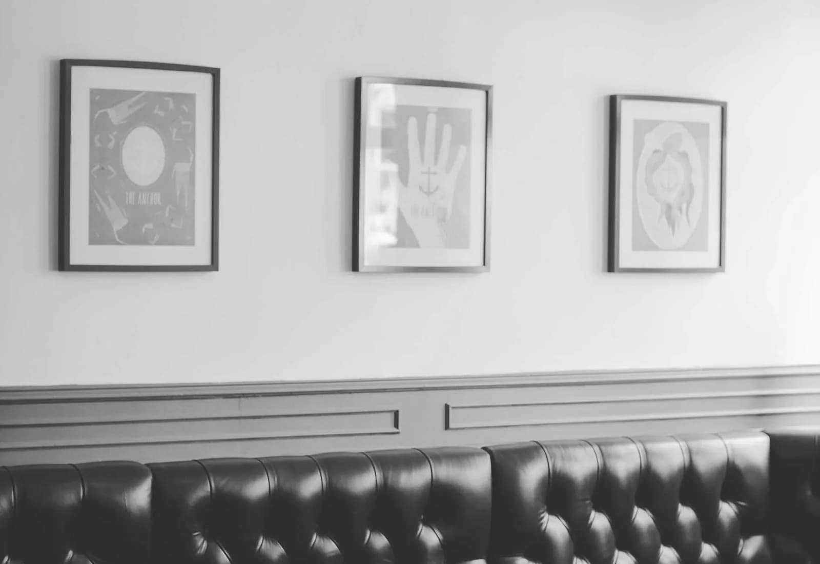 Trois cadres alignés sur le mur d'un atelier.