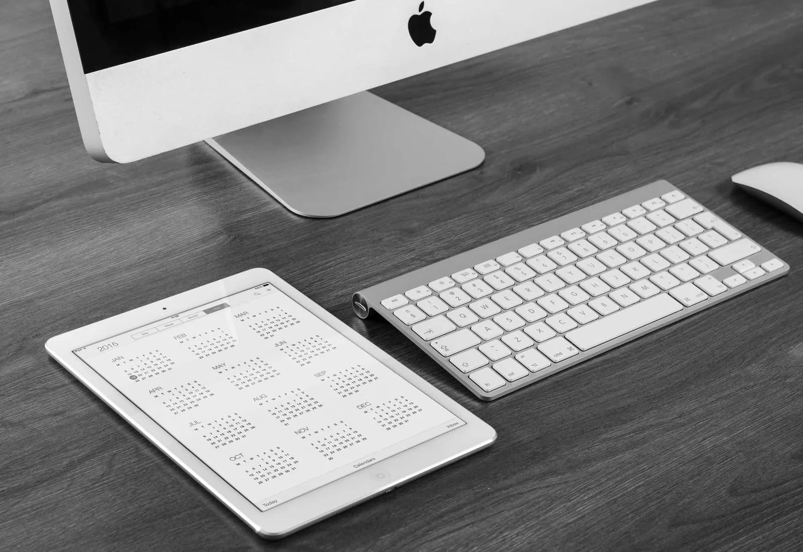 Poste de travail vu de dessus : écran, clavier et feuilles imprimées.